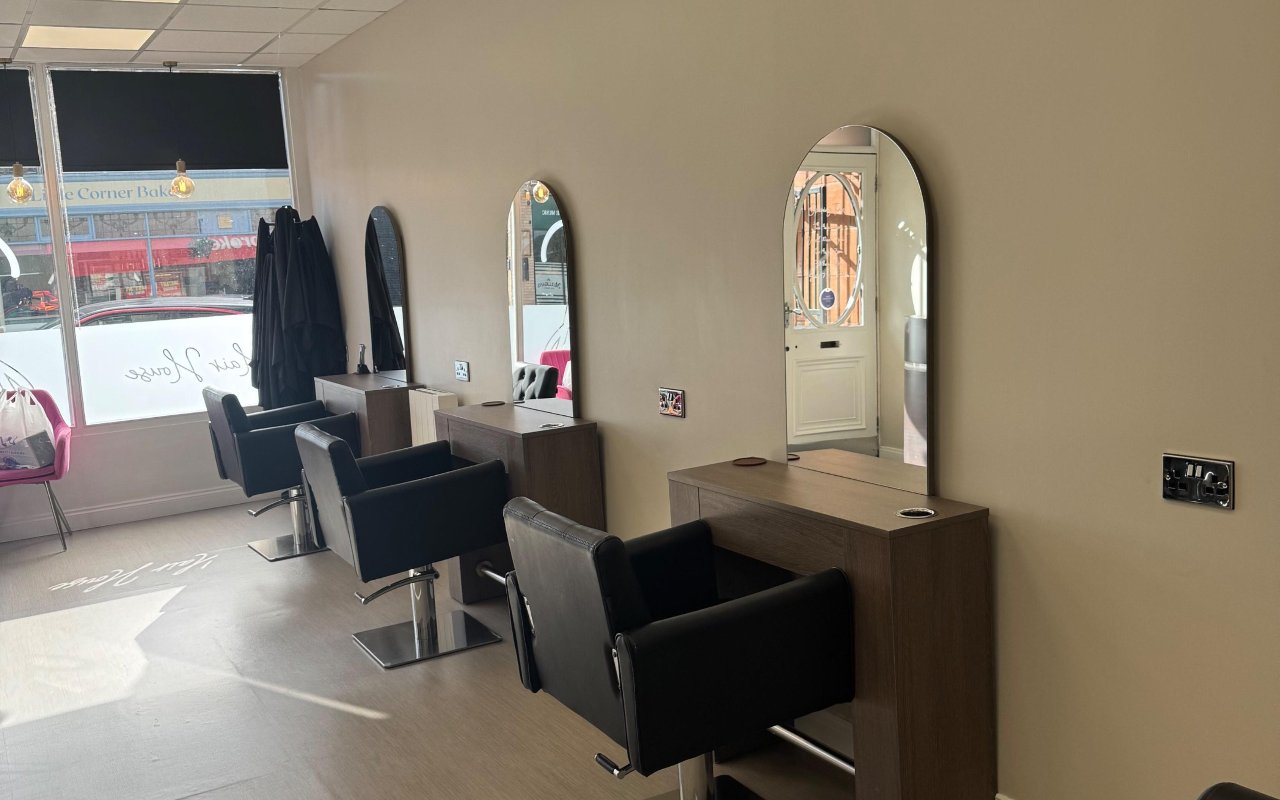 Styling chairs and arched mirrors inside Hair House Bingley