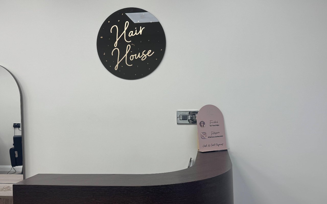 The Hair House reception desk and logo sign